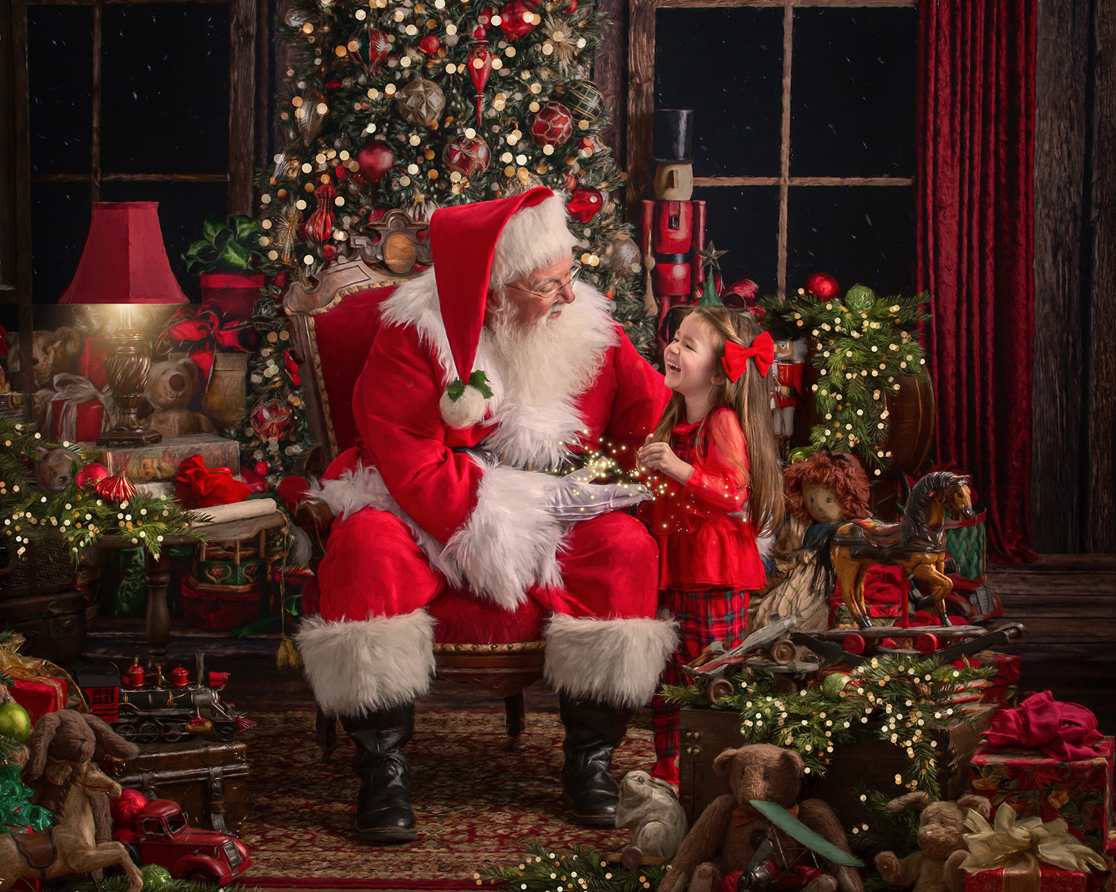 Little girl smiling and talking with Santa in magical Studio C Santa Experience portrait setting