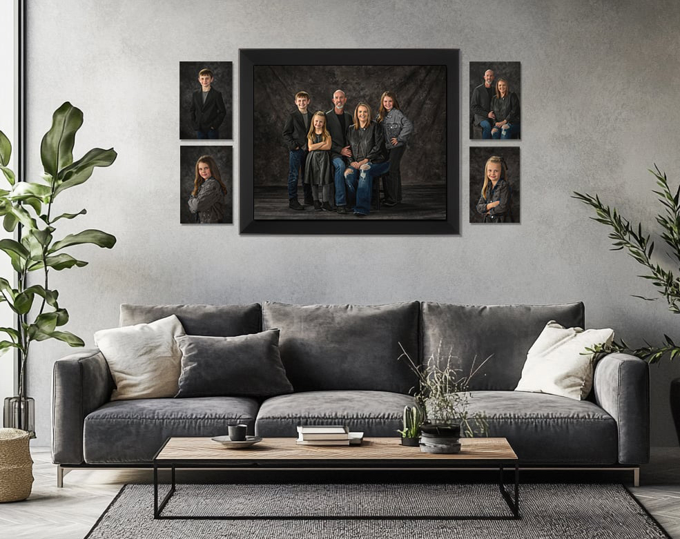 Beautiful family wall portrait gallery displayed above a modern gray sofa in an elegant living room by Studio C Fine Art Photography.