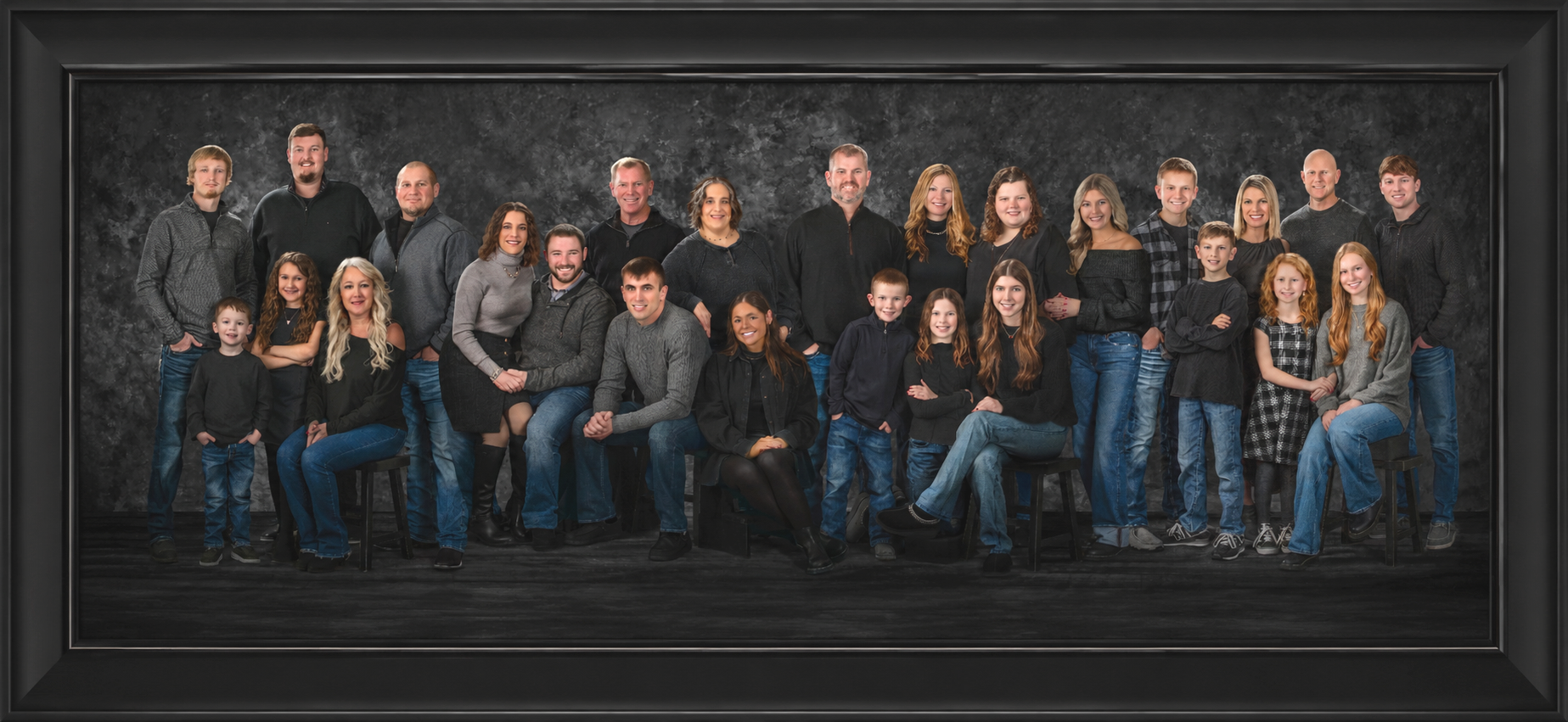 Large multi-generational family portrait featuring multiple families and children displayed in a classic black frame by Studio C Fine Art Photography.